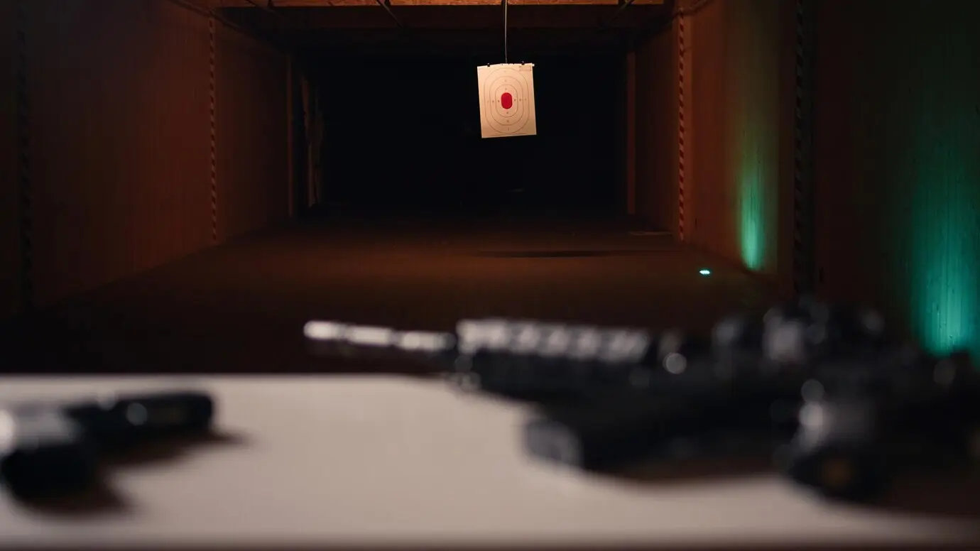 Nahaufnahme von Pistole und Gewehr auf einem militärischen Schießstand.