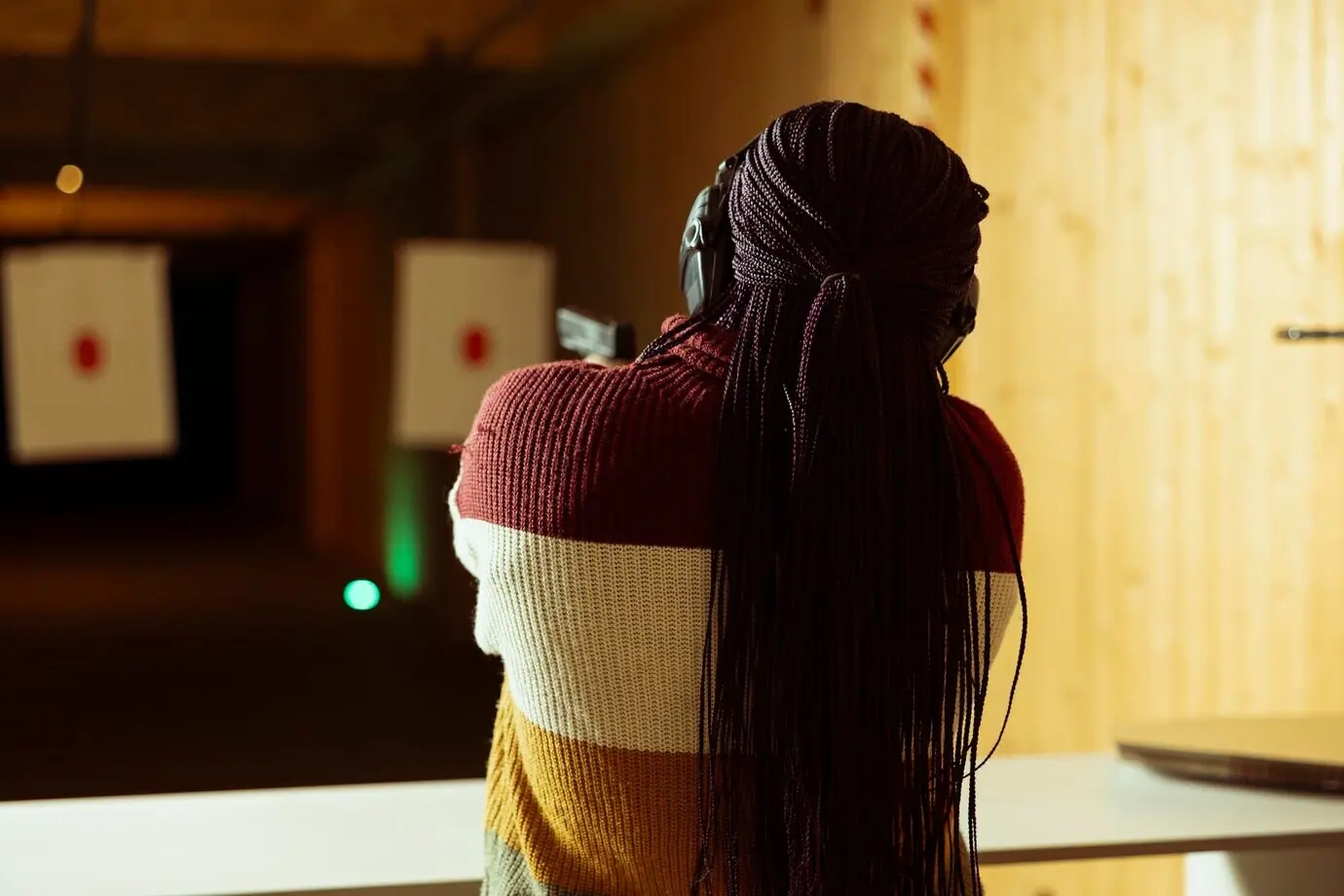 Frau auf einem Schießstand beim Freizeitschießen mit einer Pistole.