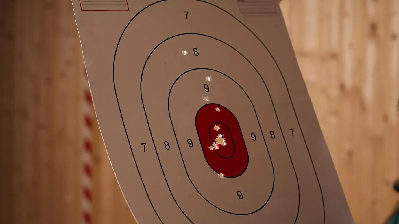 Nahaufnahme eines Mannes, der eine Schusswaffe hält und das Freizeitschießen in der Halle genießt.