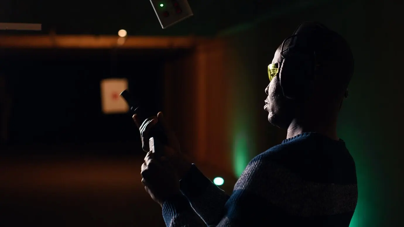 Ein Kunde am Schießstand schaut durch ein Vergrößerungsgerät, um zu überprüfen, ob er die Zielmitte getroffen hat.